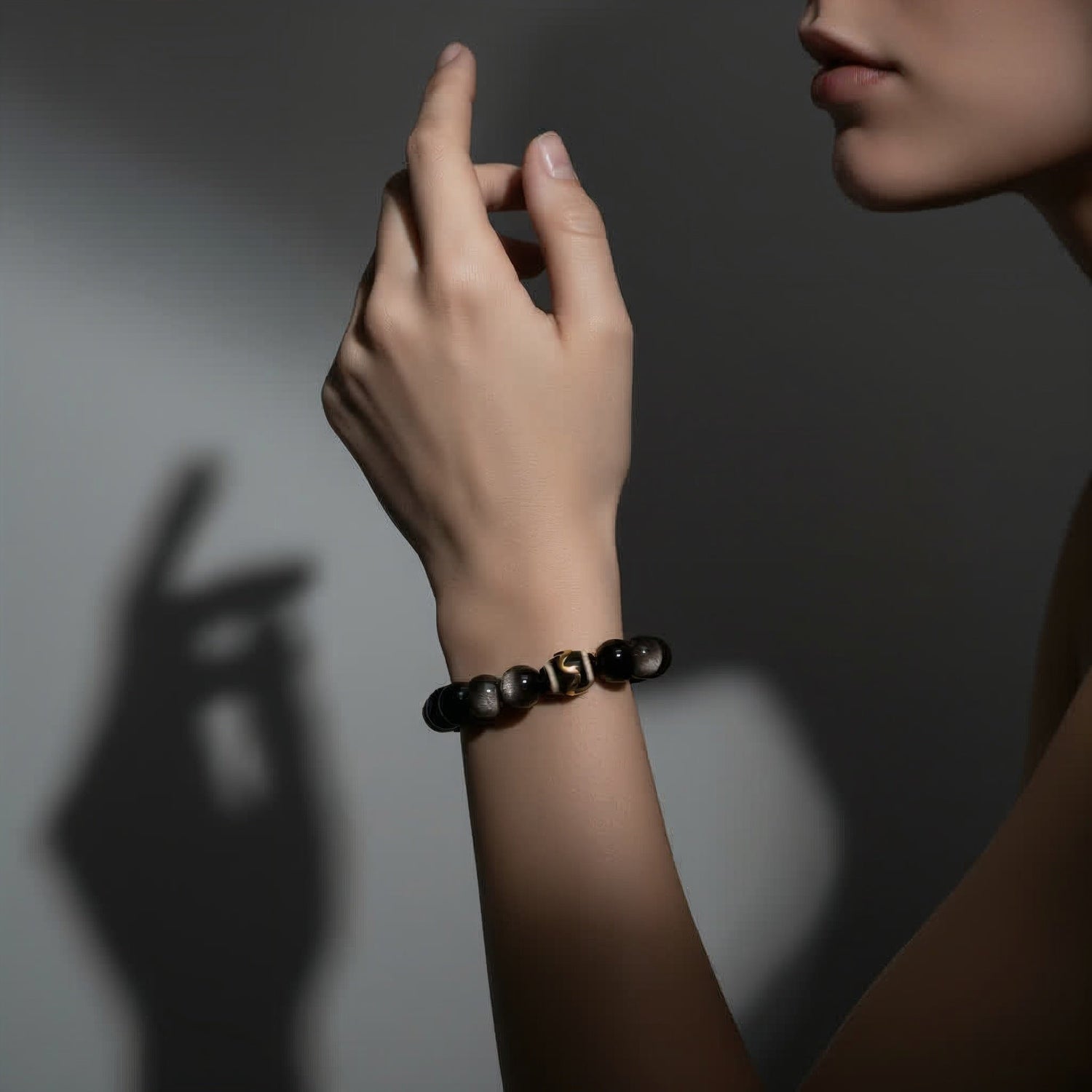 Hand holding natural black obsidian crystal from Hokkaido, Japan — grounding and protection stone.