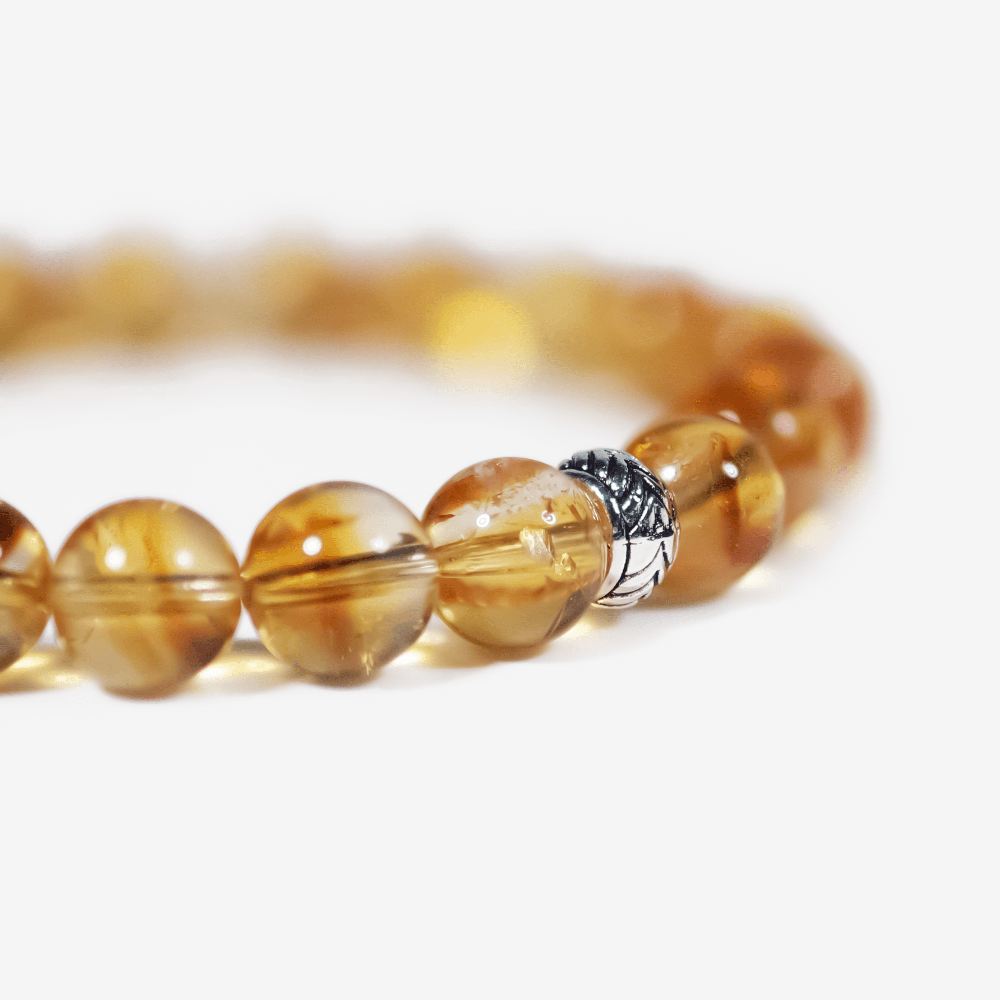 Close-up of hand-polished citrine gemstone beads with sterling silver accent