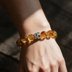 Amber Glow natural citrine bracelet worn on a woman’s wrist in warm sunlight and soft shadow.