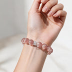 Aurora Bloom Strawberry Quartz bracelet on the wrist, showing its rosy-pink color and statement 12mm beads.
