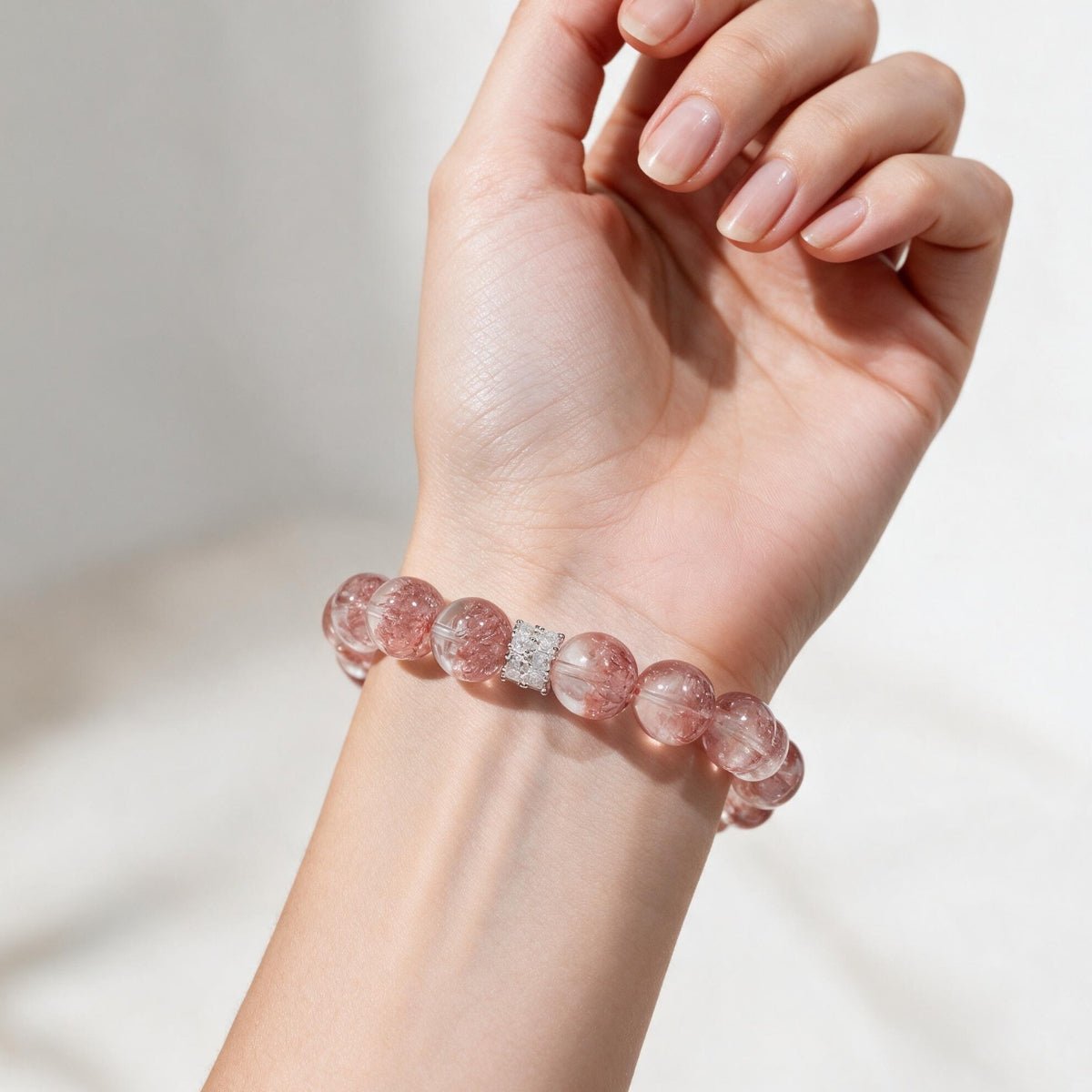Aurora Bloom Strawberry Quartz bracelet on the wrist, showing its rosy-pink color and statement 12mm beads.
