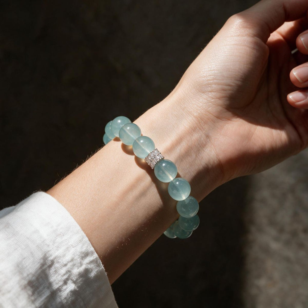 Woman wearing the Blue Horizon Silver Halo aquamarine bracelet with a white sleeve