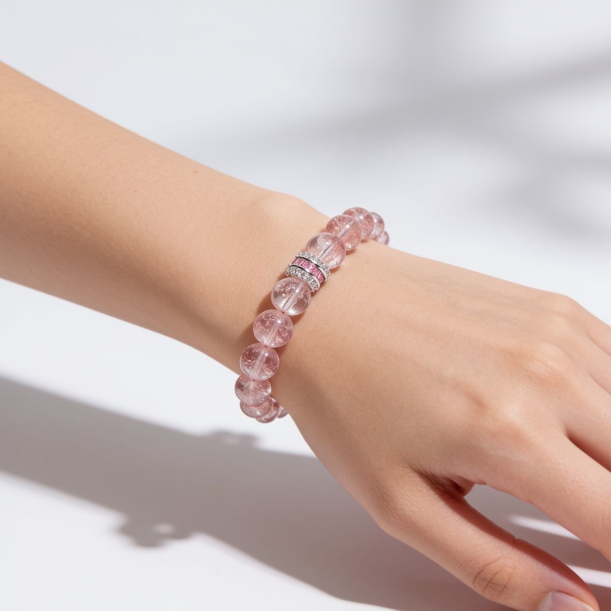 Blush Harmony Strawberry Quartz Bracelet worn on the wrist with 10mm rosy-pink beads and silver-tone centerpiece