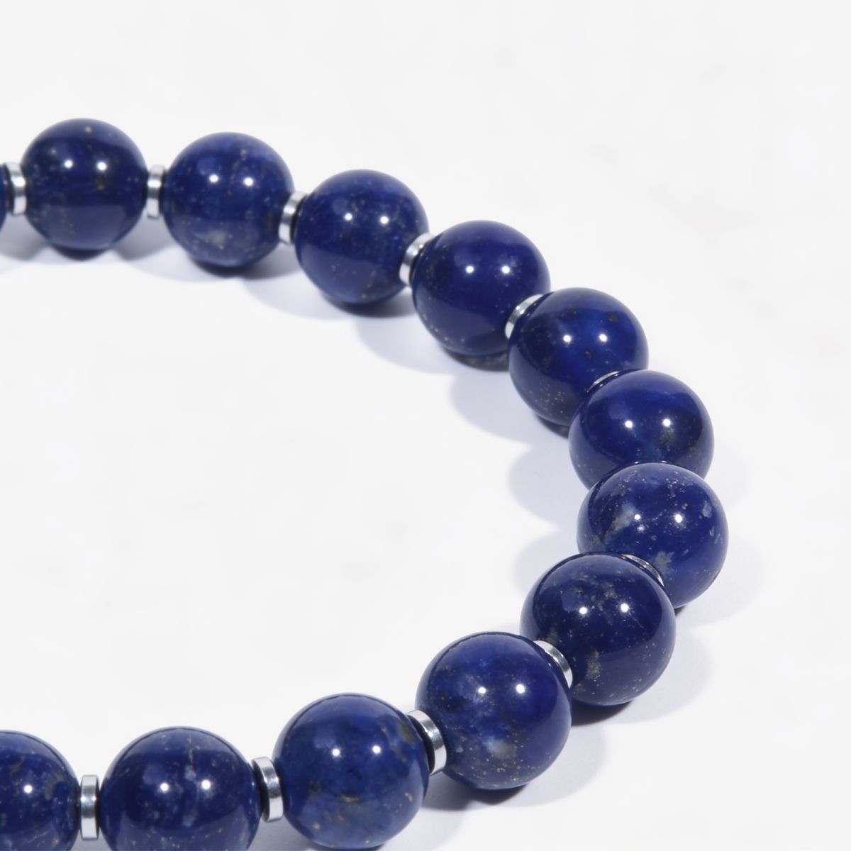 Detailed view of Celestial Lapis Lazuli Bracelet showing polished blue beads, natural golden pyrite flecks, and silver spacer accents