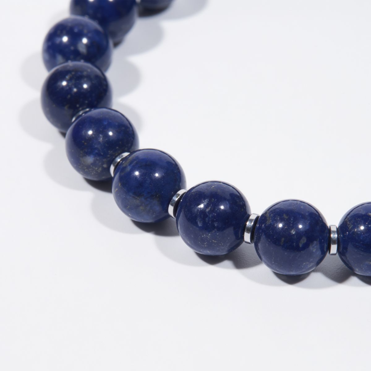 Close-up of natural lapis lazuli beads showing deep celestial-blue color, subtle pyrite flecks, and silver-toned spacers
