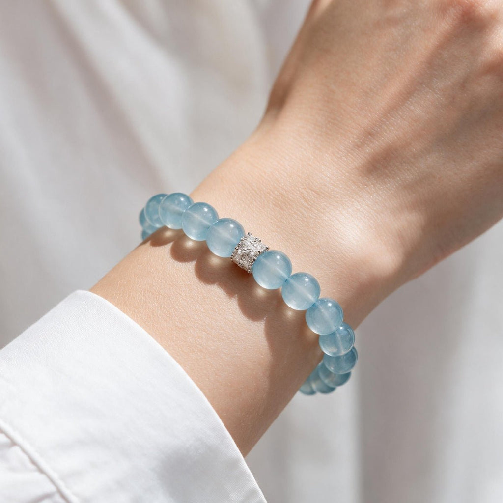 Woman wearing the Coastal Elegance aquamarine bracelet with a white sleeve for polished everyday styling.