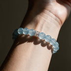 Coastal Elegance aquamarine bracelet on a woman’s wrist in warm directional light.