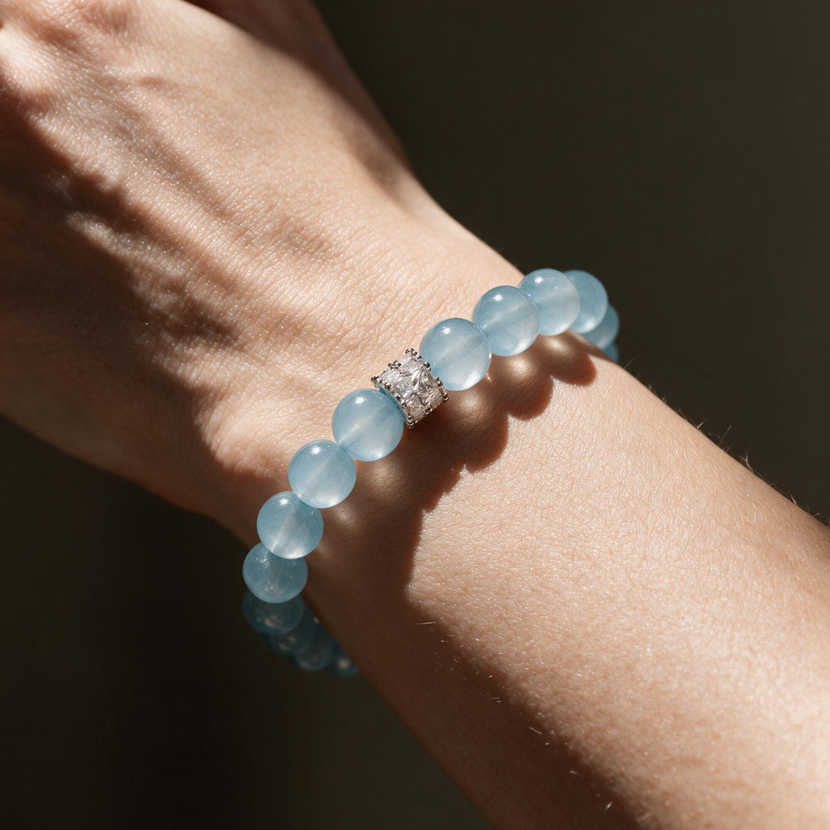 Coastal Elegance aquamarine bracelet worn in sunlight, showing its soft blue 10mm bead profile.