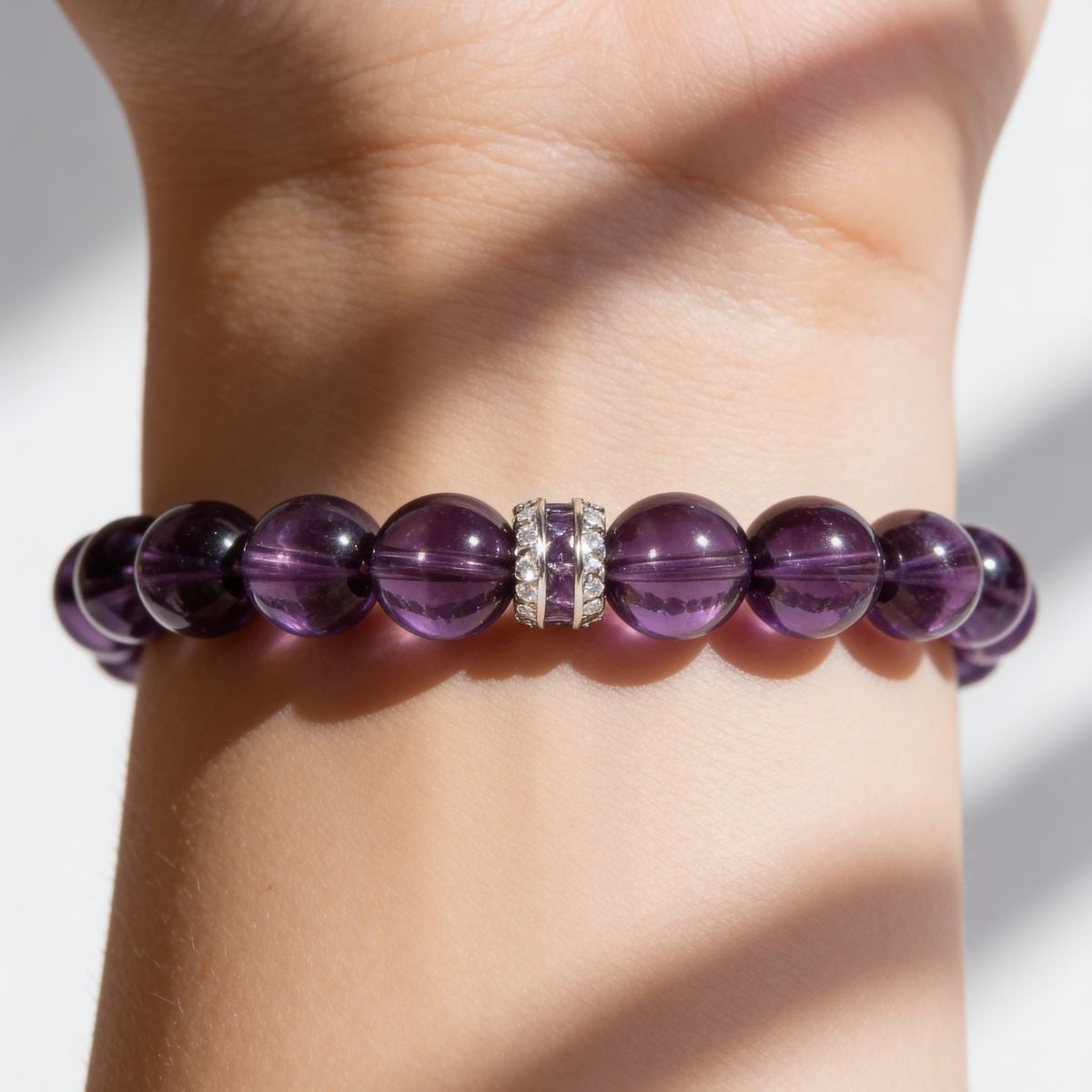 Close-up of the Eternal Elegance bracelet worn on a woman’s wrist, showing translucent violet beads and sterling silver detail.