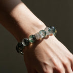 Green Phantom Quartz bracelet worn on a bare wrist with warm light and soft shadow