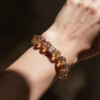 Fortune Koi Hematoid Quartz bracelet worn on the wrist with warm golden-red gemstone tones
