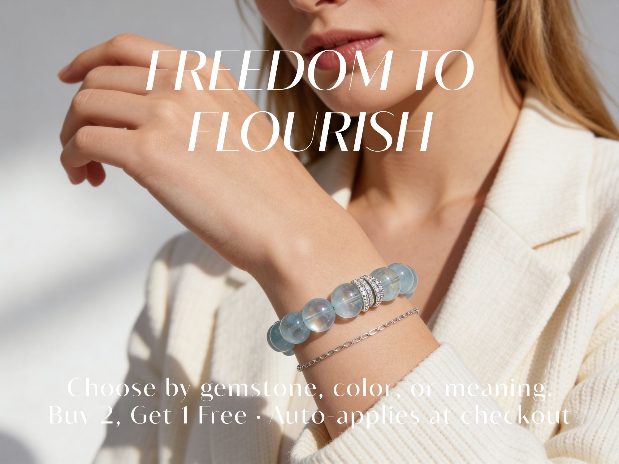 Model wearing a natural aquamarine crystal bracelet with “Freedom to Flourish” text, promoting the July Crystal Event and Buy 2, Get 1 Free offer.