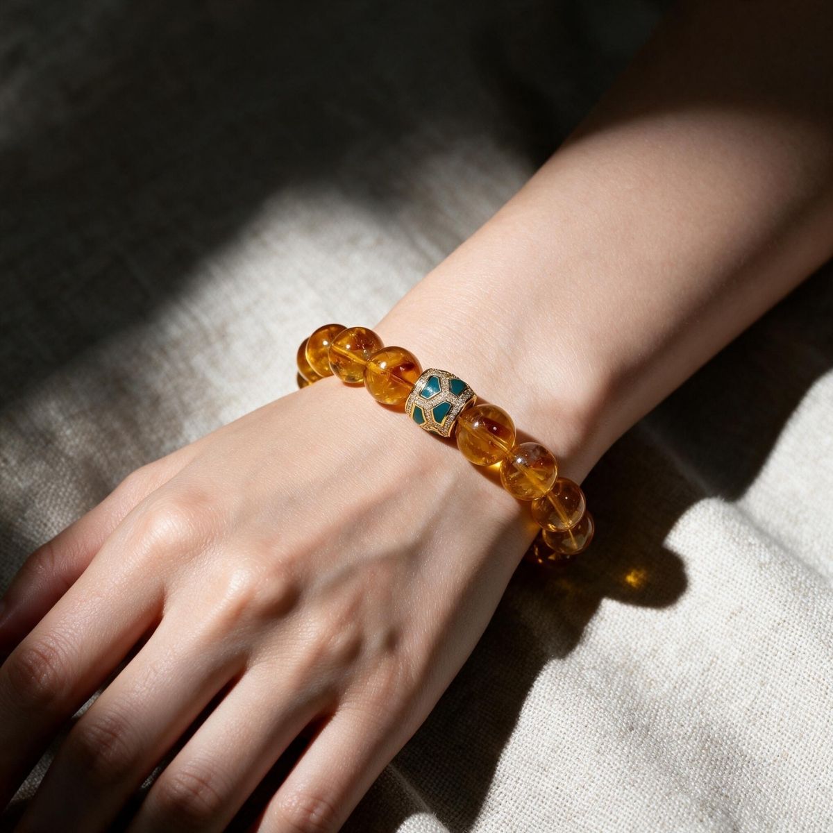 Lifestyle wrist view of Golden Signature Brazilian Citrine Bracelet with Gold Pavé Barrel centerpiece and warm golden citrine beads.