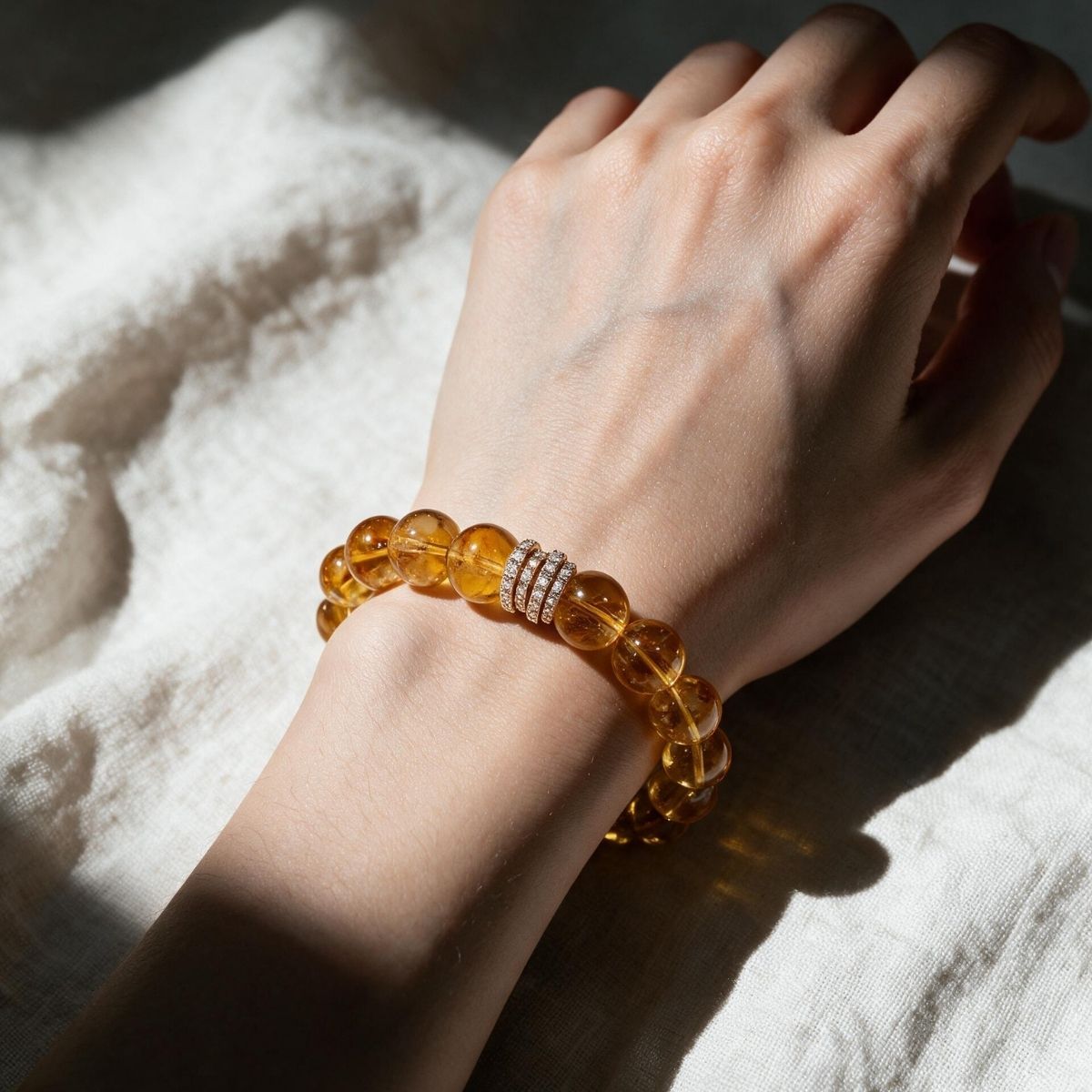 Close-up of Golden Signature Brazilian Citrine Bracelet showing hand-polished 12mm citrine beads and Gold Pavé Barrel centerpiece.