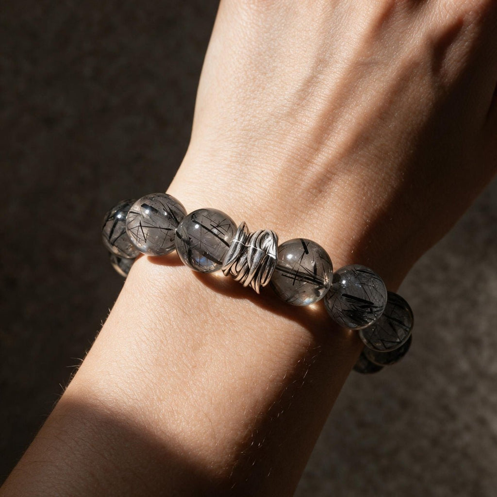 Guardian Black Rutilated Quartz Bracelet worn on a woman's wrist in warm natural light