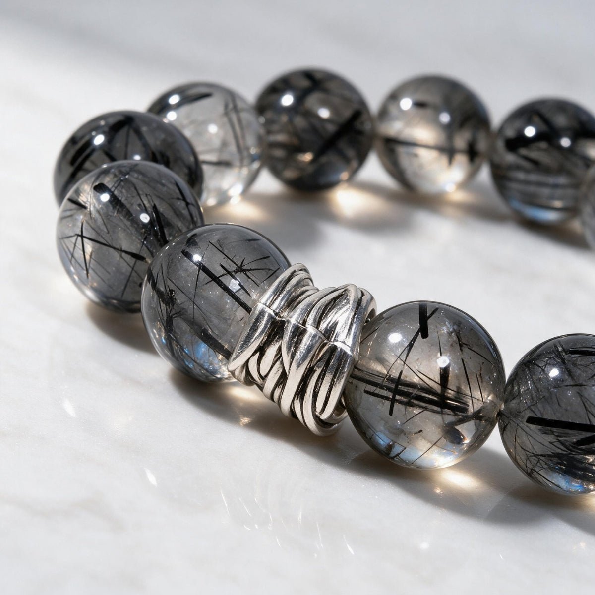 Close-up of natural Black Rutilated Quartz beads showing dark rutile threads and silver detailing