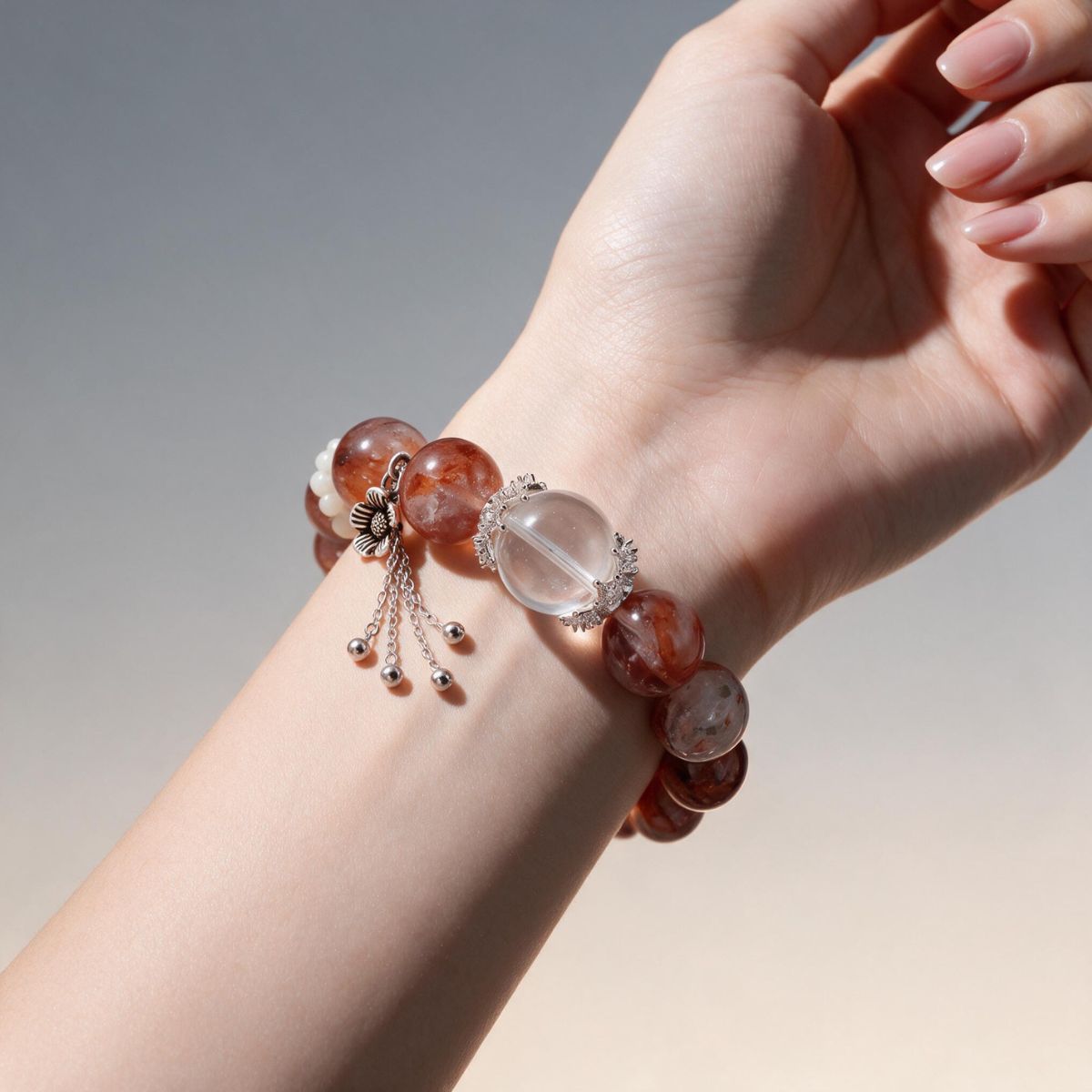 Fire Quartz 12mm beaded bracelet worn on the wrist with natural red inclusions and silver details