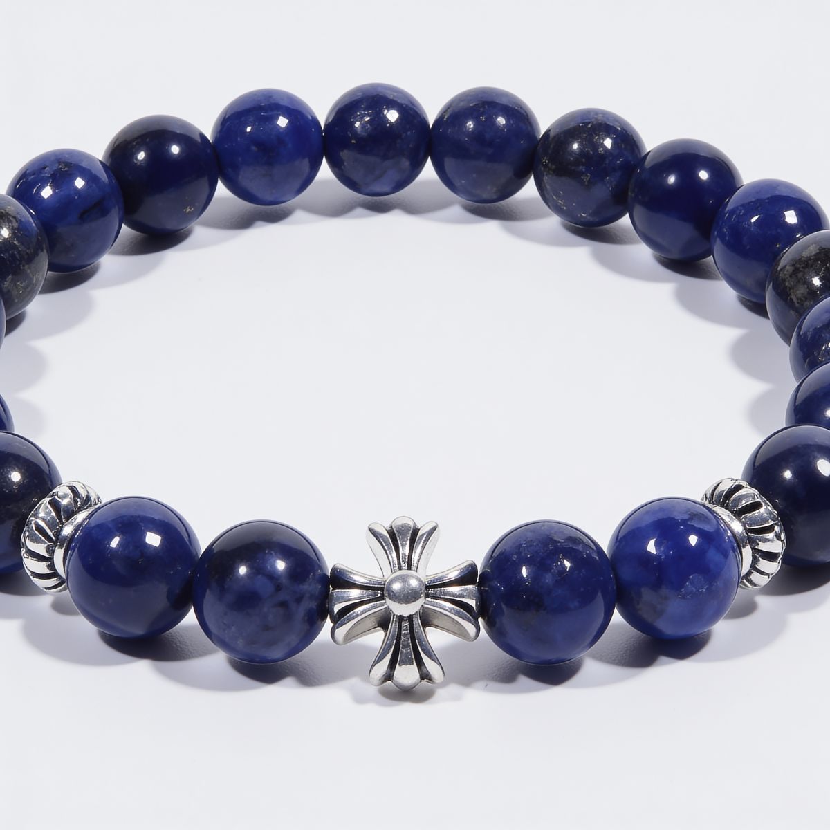 Close-up of sterling silver cross centerpiece with polished lapis lazuli beads, natural pyrite flecks, and silver metal accents