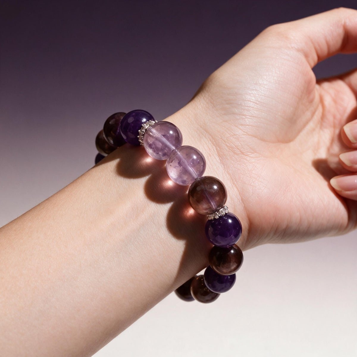 Woman wearing the Lunar Grace amethyst and lepidolite bracelet against a soft purple background