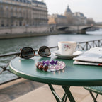 Lunar Grace amethyst and lepidolite bracelet styled on a Paris café table by the waterfront