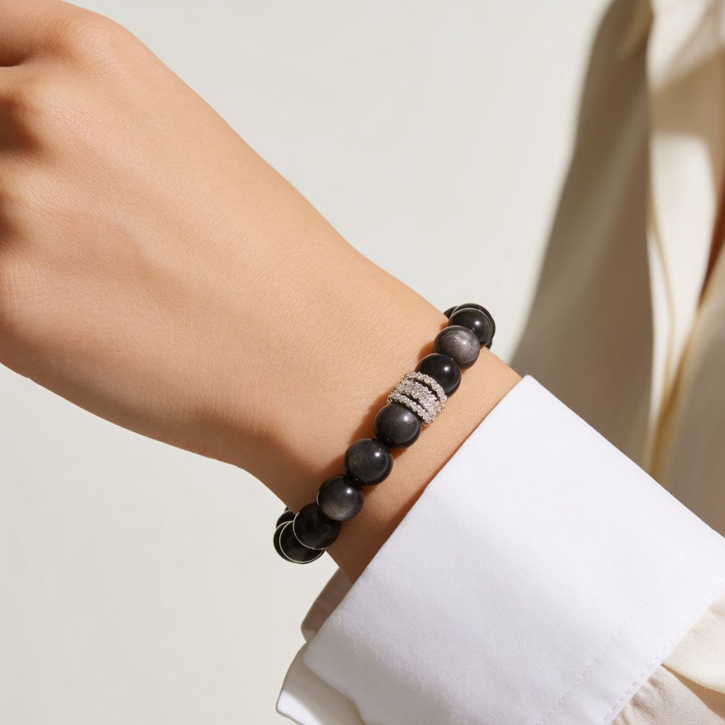 Midnight Shield Silver Sheen Obsidian Beaded Bracelet styled with a white shirt for a modern feminine look