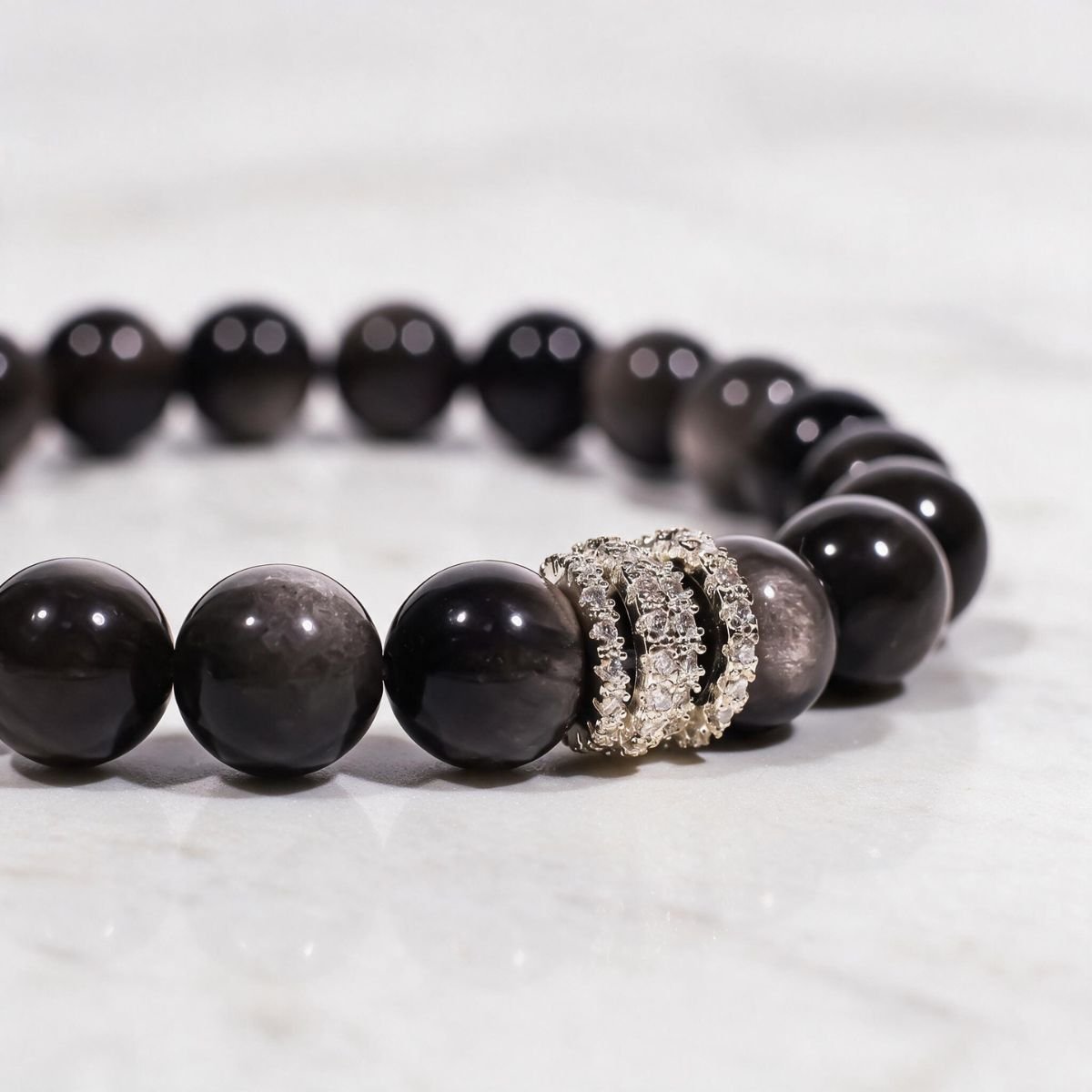 Close-up of hand-polished Silver Sheen Obsidian beads and the silver-tone pavé ring detail.