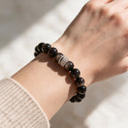 Silver Sheen Obsidian bracelet styled on a woman’s wrist with a neutral knit sleeve.