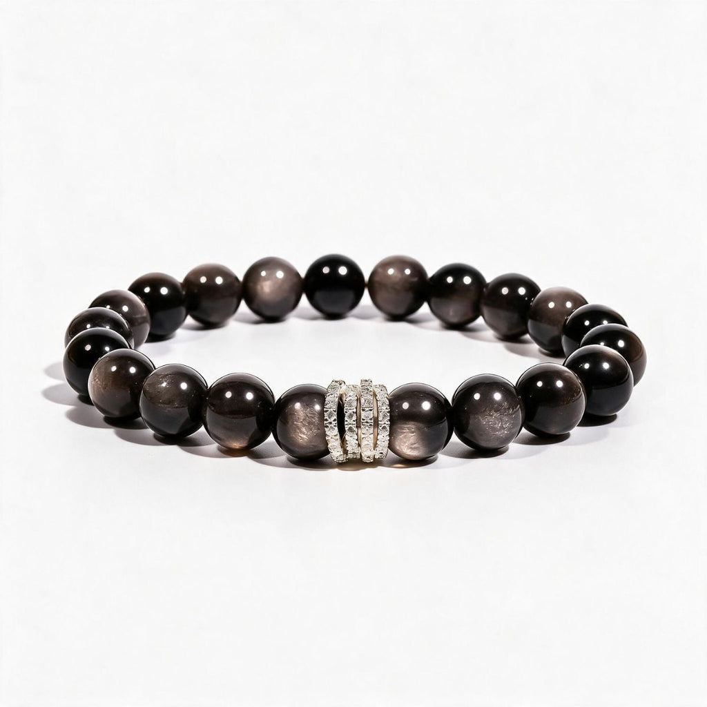 Midnight Shield Silver Sheen Obsidian bracelet with 10mm black beads and a silver-tone pavé centerpiece.