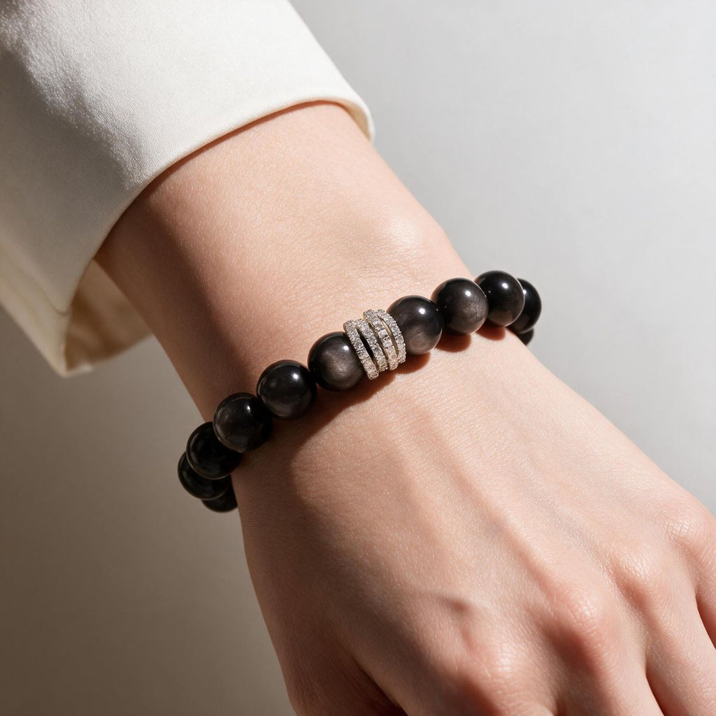 Natural Silver Sheen Obsidian bracelet worn with a cream sleeve for polished everyday style.