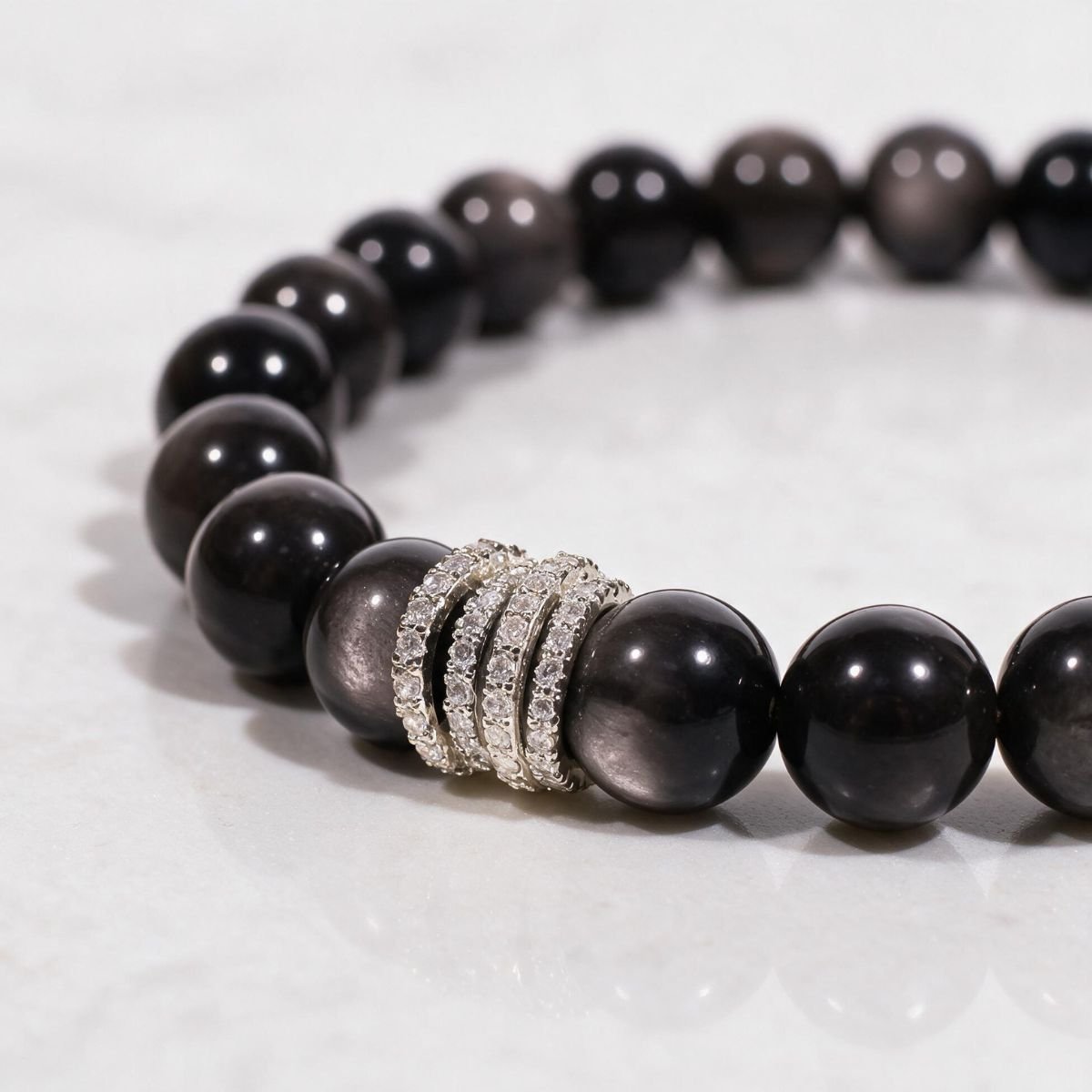 Close-up of natural Silver Sheen Obsidian beads and the light-catching silver-tone pavé centerpiece.