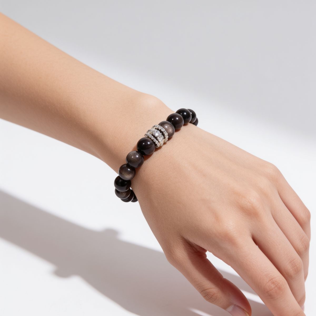 Natural Silver Sheen Obsidian crystal bracelet worn on the wrist with a polished black and silver look