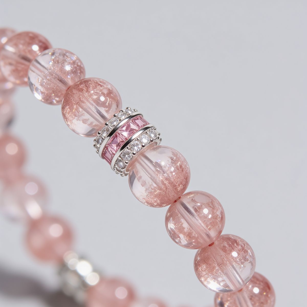 Natural Super-Seven Strawberry Quartz beads with soft shimmer and a refined silver-tone pink centerpiece