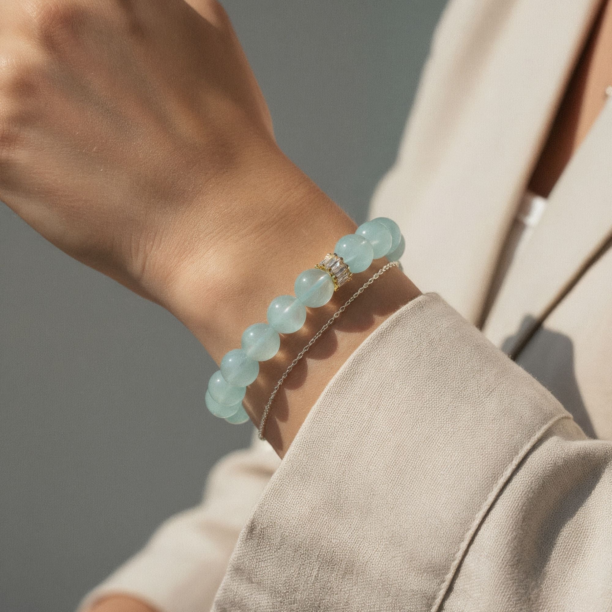 Natural aquamarine bracelet styled on wrist with cream blazer for everyday wear