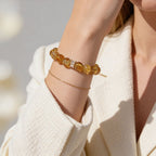 Natural Brazilian Citrine beaded bracelet worn on wrist with elegant cream outfit