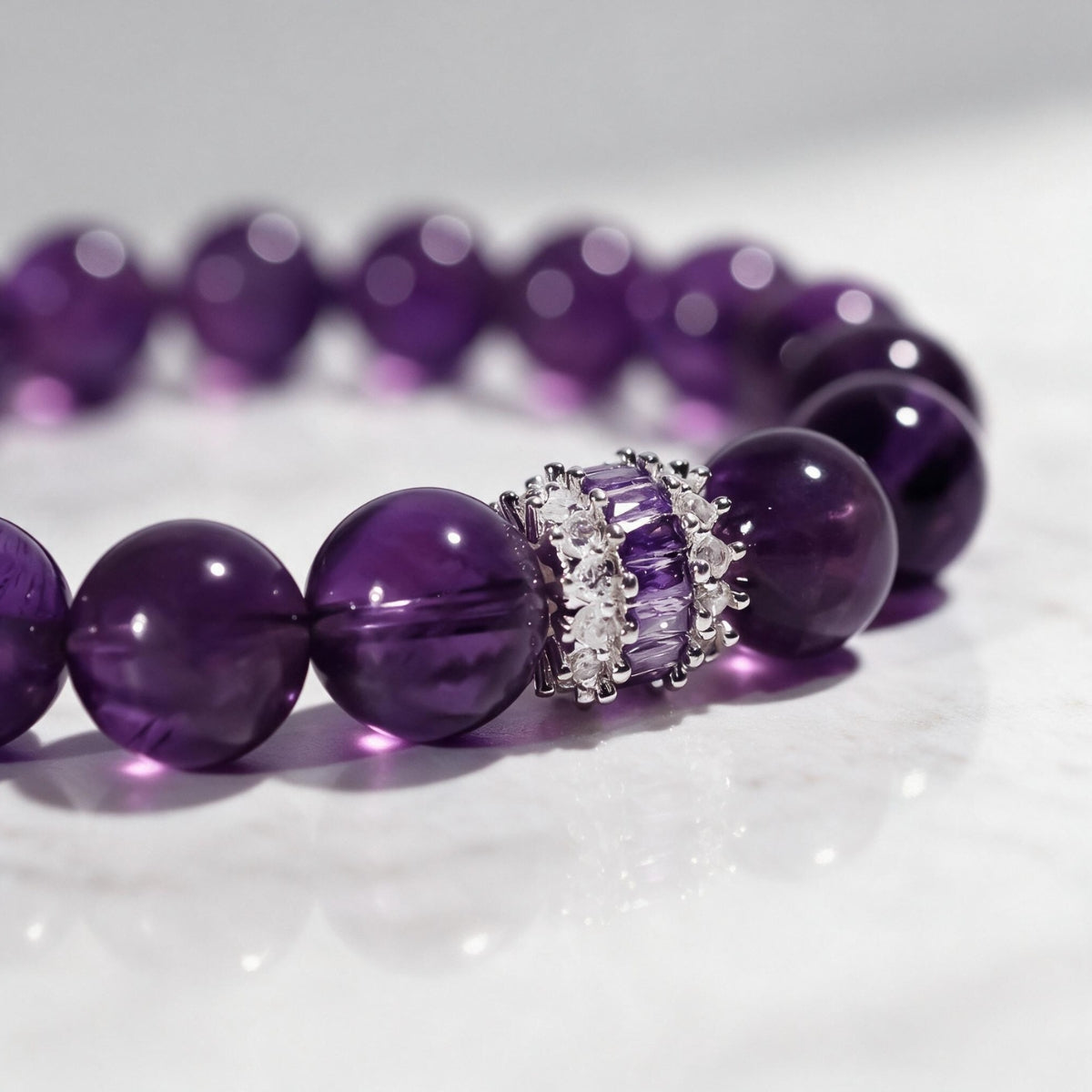 Close view of rich violet amethyst beads and the light-catching inlaid centerpiece.