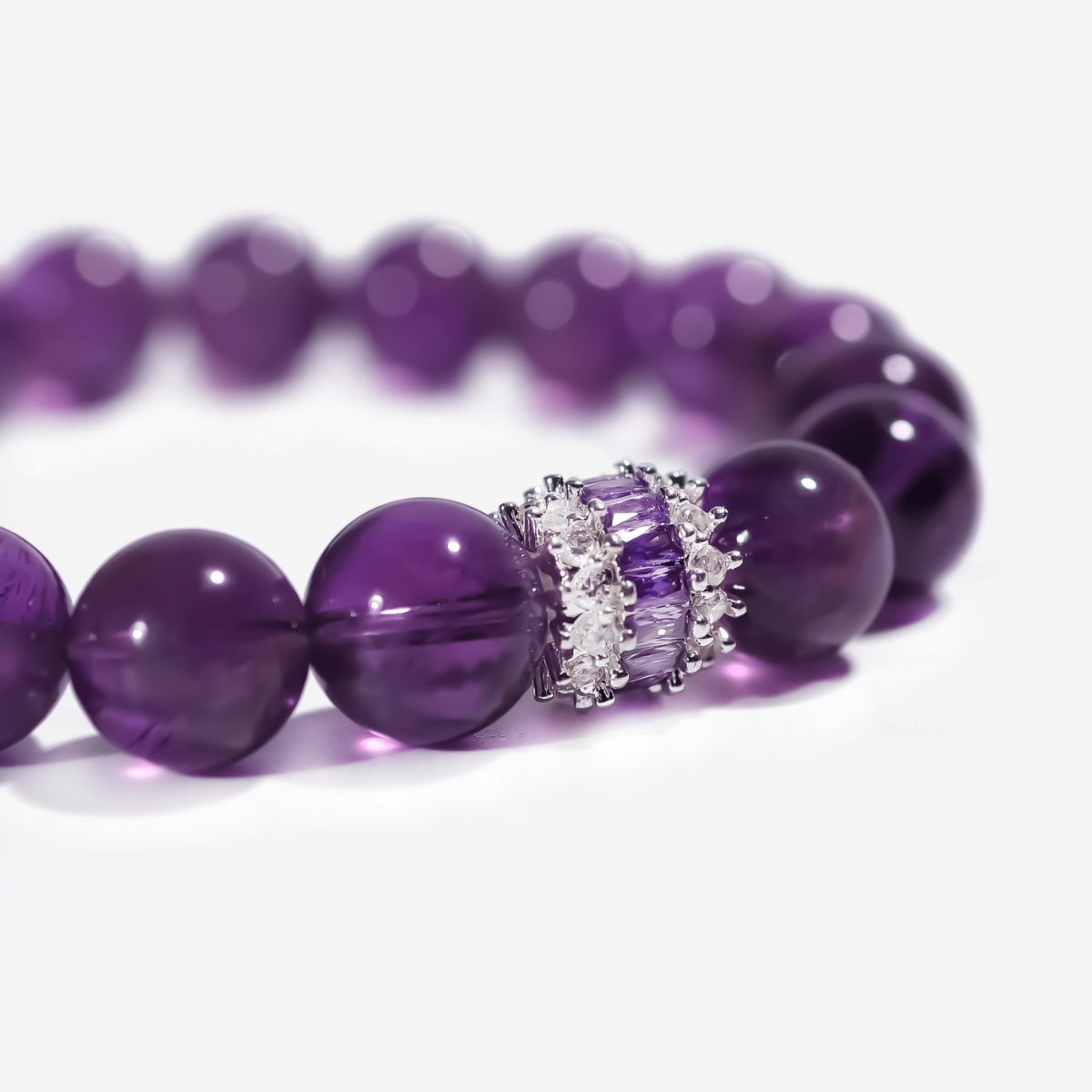 Close-up of natural Sri Lankan amethyst beads with rich violet tones and refined inlaid centerpiece detail