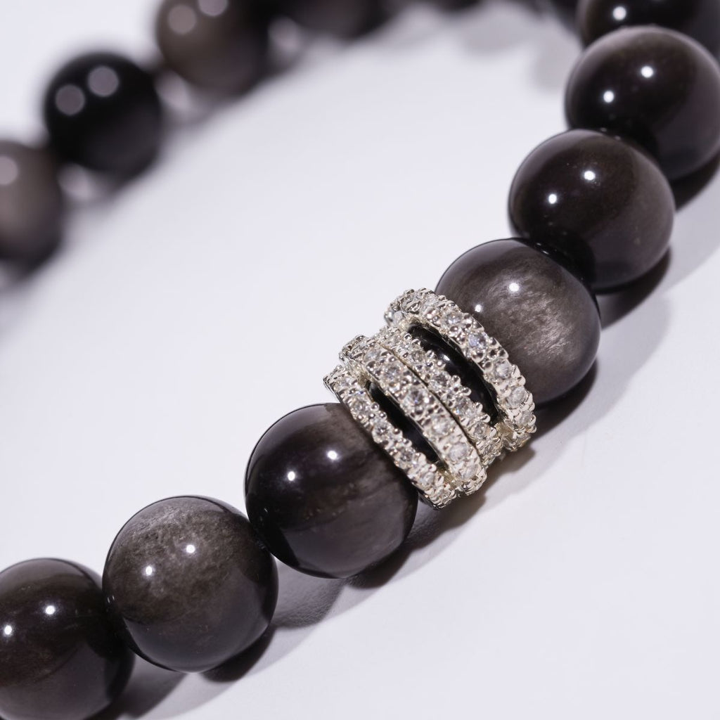 Close-up of Silver Sheen Obsidian beaded bracelet with reflective black beads and sparkling pavé ring centerpiece